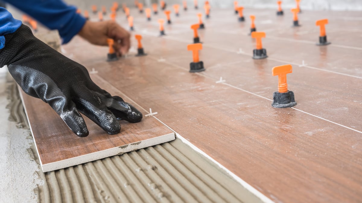 Worker laying tile floor